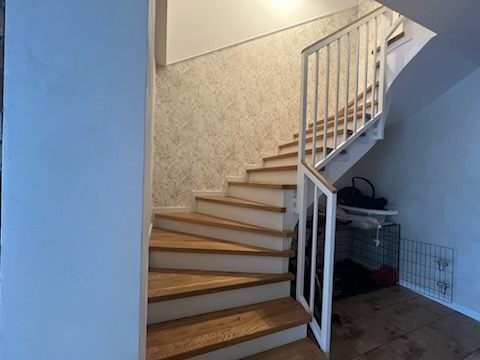 Biała balustrada metalowa przy schodach z łukiem